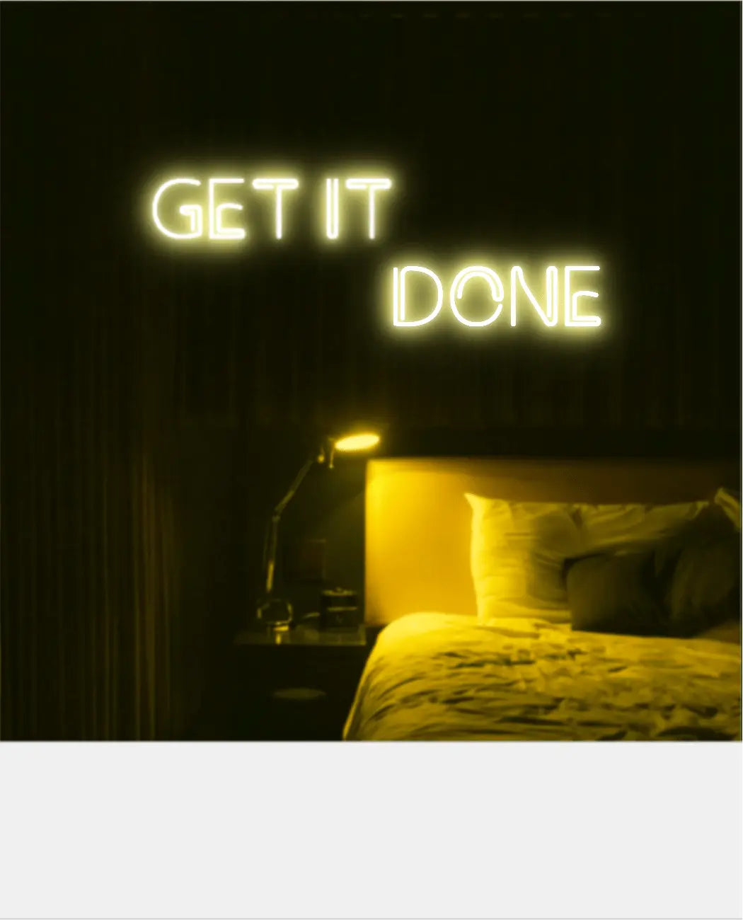 Get It Done LED Neon Light Sign in yellow, featuring two offset lines of block lettering illuminated above a bed.