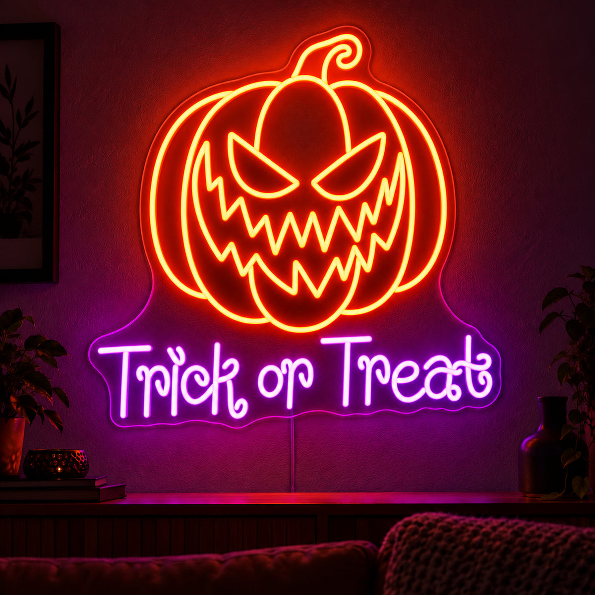 Trick or Treat Pumpkin Neon Sign featuring an orange pumpkin with a jagged grin above purple Trick or Treat lettering, displayed on a dark wall above a wooden sideboard.