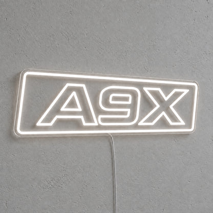 A9X Torana LED Neon Sign in white, featuring A9X lettering inside a rectangular border on a grey wall.