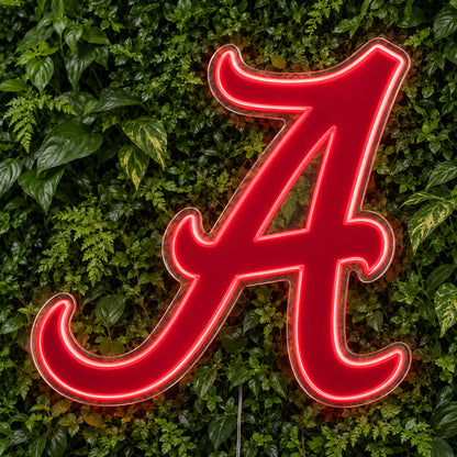 Alabama LED Neon Sign, featuring team logo displayed on a green foliage wall.
