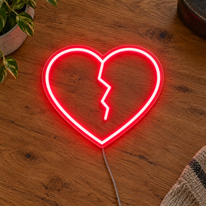 Broken Heart LED Neon Light Sign in red, featuring broken-heart outline on a wooden surface.