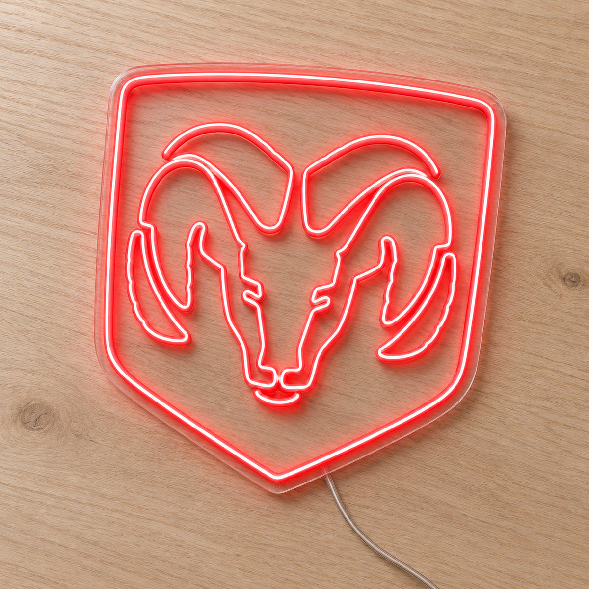 Dodge Ram Logo LED Neon Sign in red, featuring a Ram head inside a shield outline on a wooden surface.