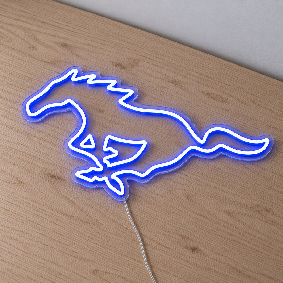 Ford Mustang Horse LED Neon Sign in blue, featuring a galloping Mustang horse outline on a wooden surface.