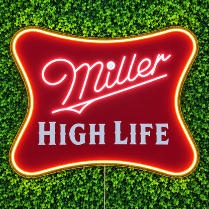 Miller High Life LED Neon Sign, featuring illuminated beer-brand logo on a green foliage wall.