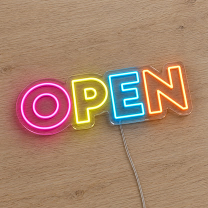 Multicolour Open LED Neon Sign in pink, yellow, blue and orange, featuring Open lettering on a wooden surface.