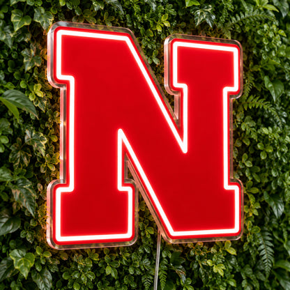 Nebraska Cornhuskers LED Neon Sign, featuring team logo displayed on a green foliage wall.
