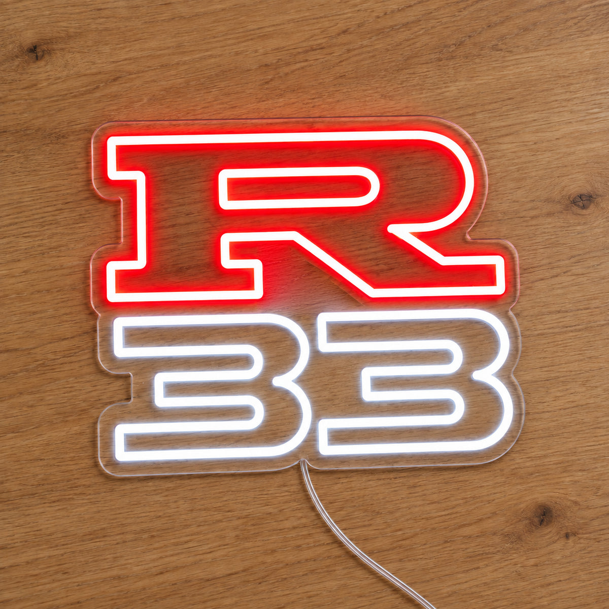 Nissan R33 LED Neon Sign in red and white, featuring R33 lettering on a wooden surface.