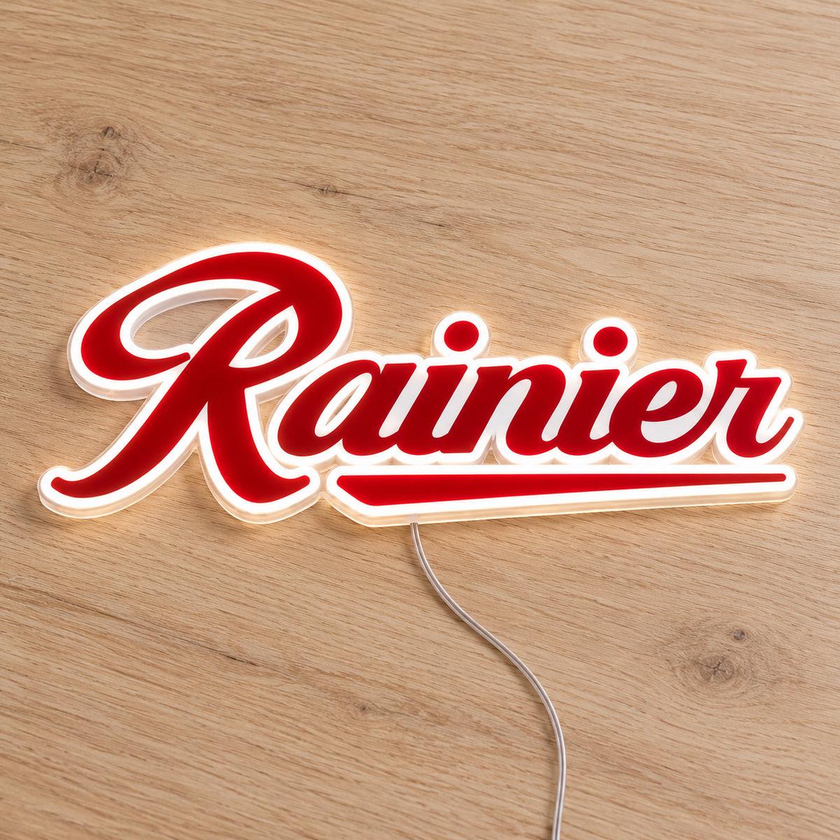 Rainier LED Neon Sign, featuring illuminated beer-brand logo on a wooden surface.