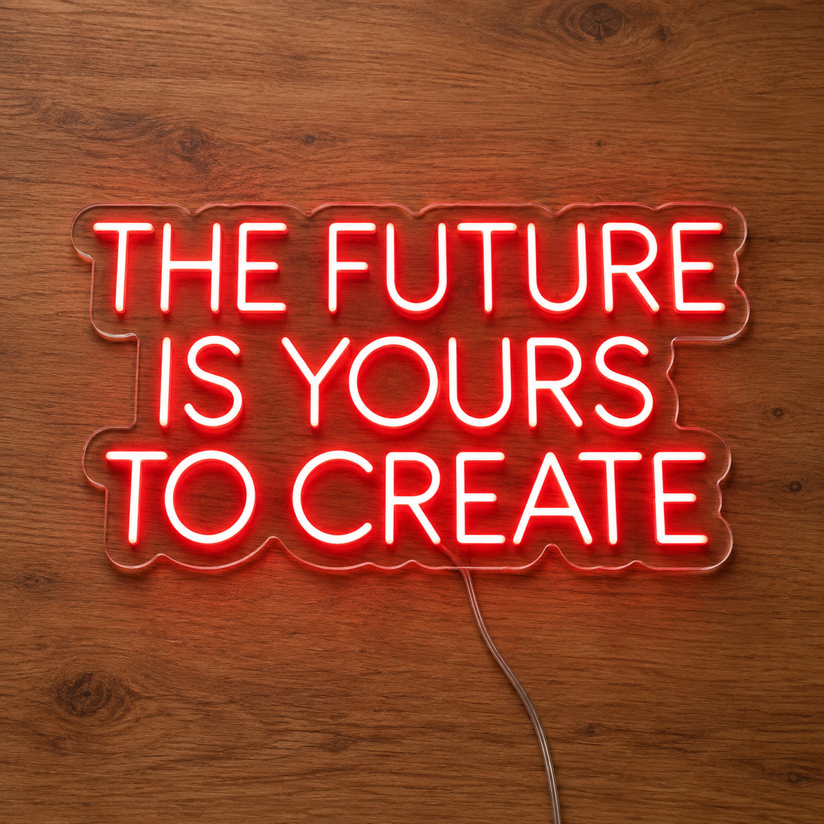 The Future Is Yours To Create LED Neon Sign in red, featuring four lines of block lettering on a wooden surface.