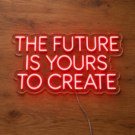 The Future Is Yours To Create LED Neon Sign in red, featuring four lines of block lettering on a wooden surface.