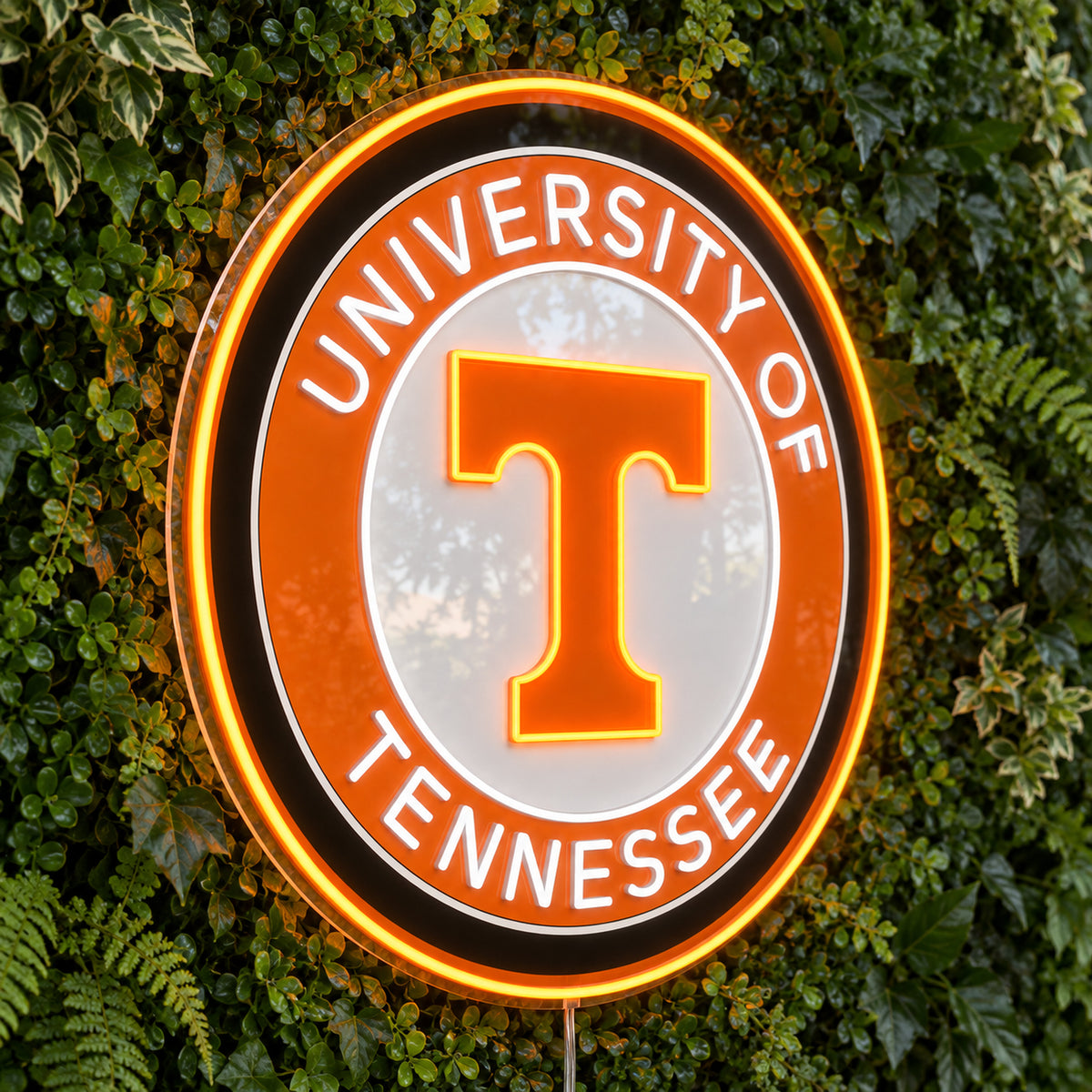 University of Tennessee Circle Logo LED Neon Sign, featuring team logo displayed on a green foliage wall.