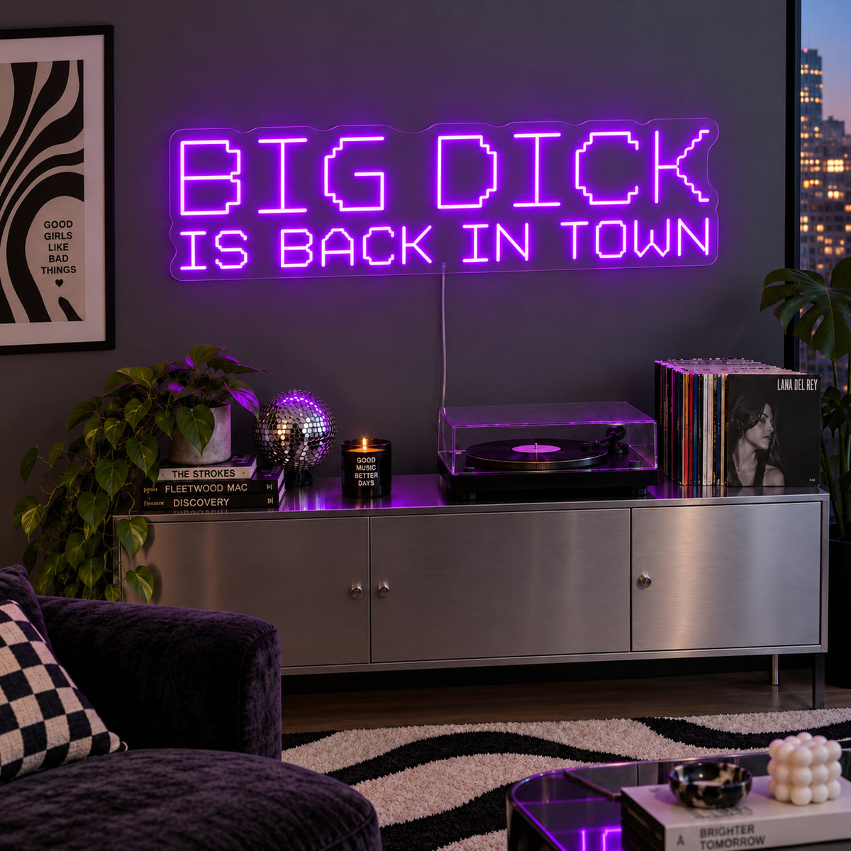 Big Dick Is Back In Town Neon Sign with purple lighting, displayed above a record player and metal sideboard.
