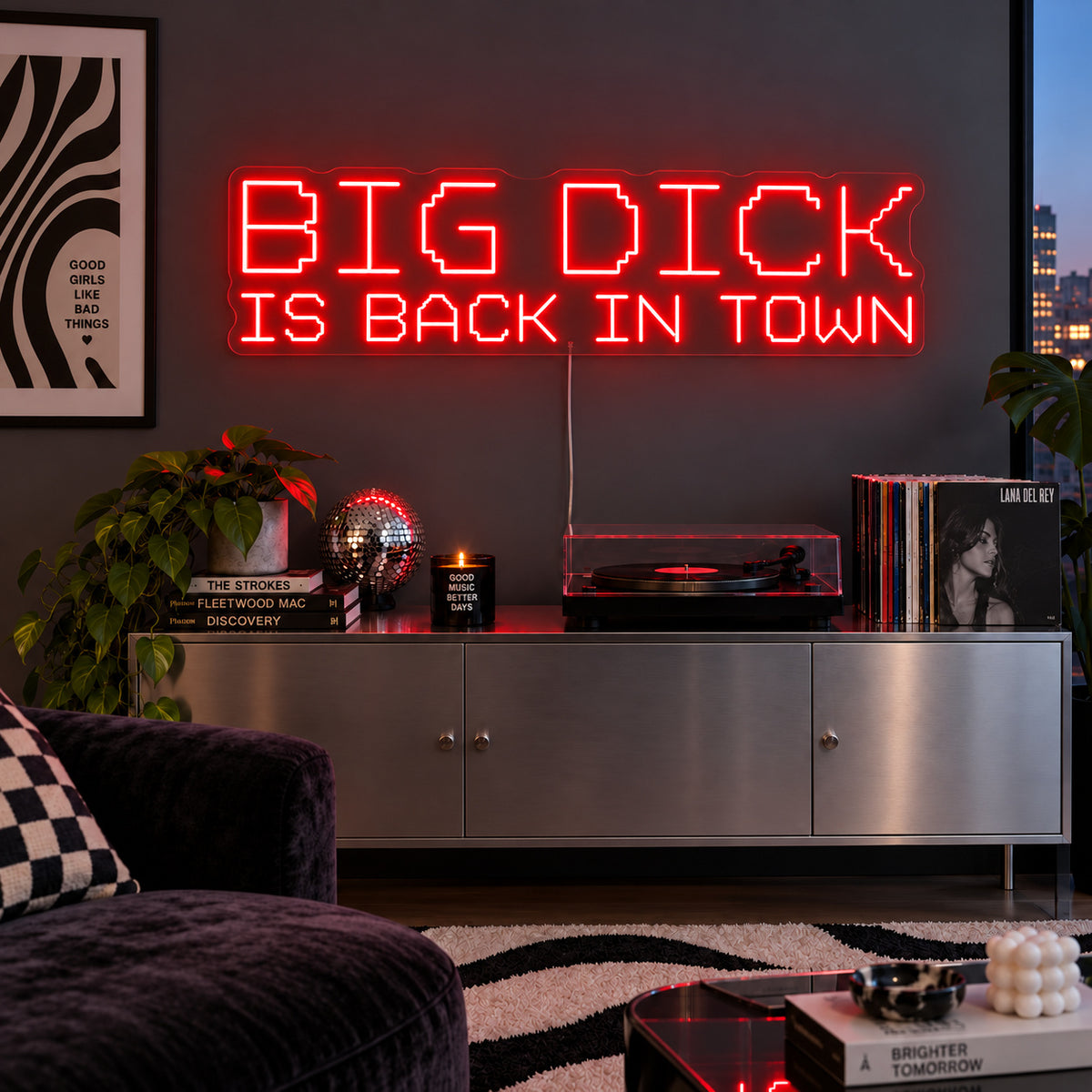 Big Dick Is Back In Town Neon Sign with red lighting, displayed above a record player and metal sideboard.