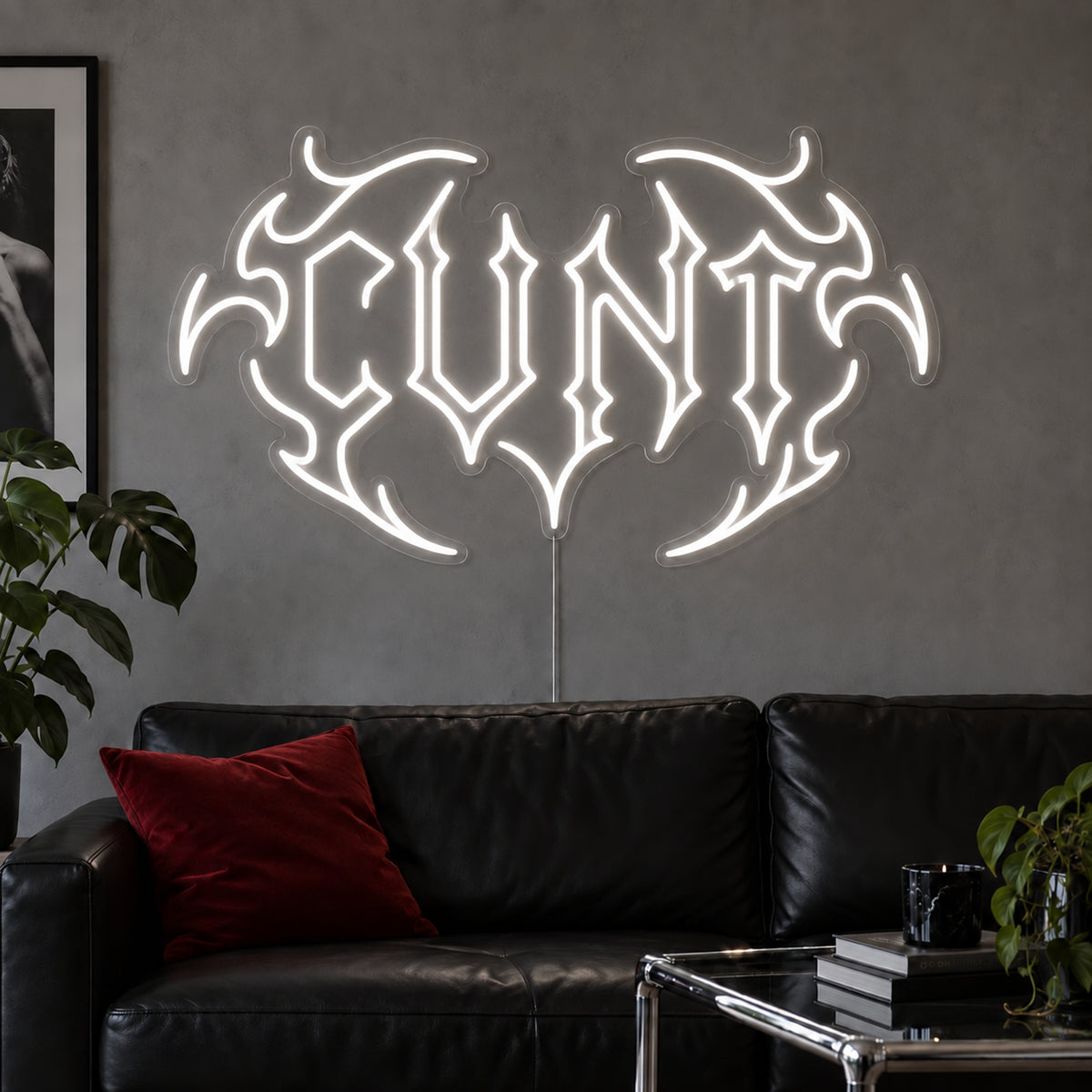 Cunt Neon Sign, RGB colour-changing option shown in white in a tribal design above a black leather sofa.