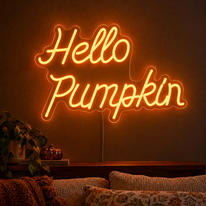 Hello Pumpkin Orange Neon Sign featuring Hello Pumpkin wording in flowing orange script over two lines, displayed on a dark wall above a wooden sideboard.