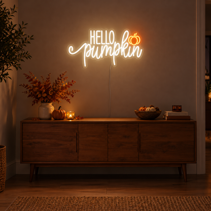 Hello Pumpkin White Neon Sign featuring white Hello Pumpkin lettering with flowing script and a small orange pumpkin, displayed on a dark wall above a wooden sideboard.
