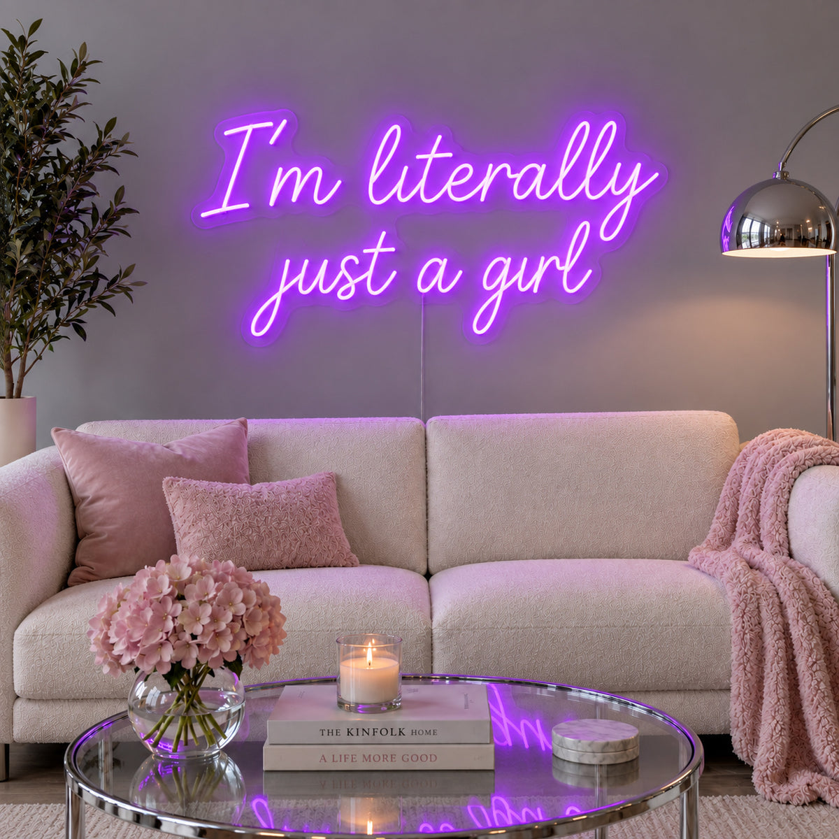 I'm Literally Just A Girl Neon Sign with purple lighting, displayed above a cream sofa.