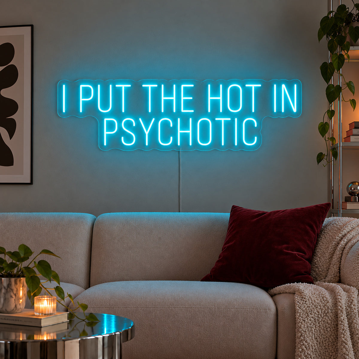 Ice Blue version of the I Put The Hot In Psychotic Neon Sign, shown above a neutral sofa.
