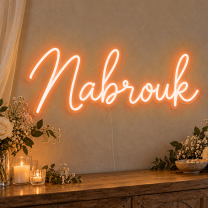 Mabrouk Neon Sign in orange LED neon on clear acrylic, angled view