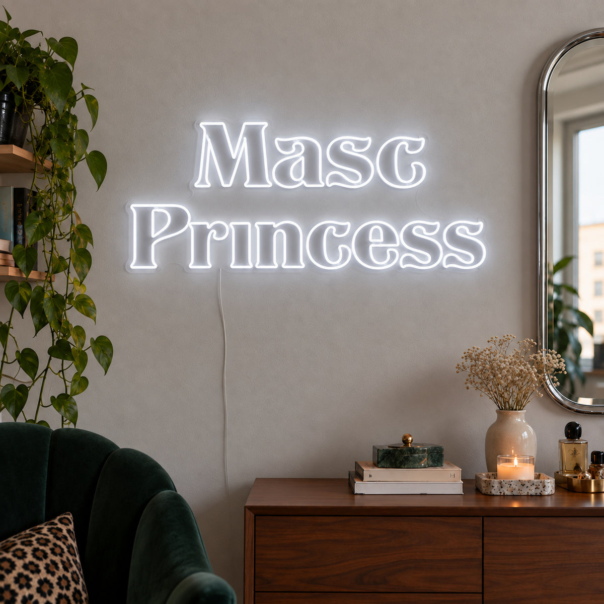 Masc Princess Neon Sign glowing white above a wooden sideboard beside a green chair.