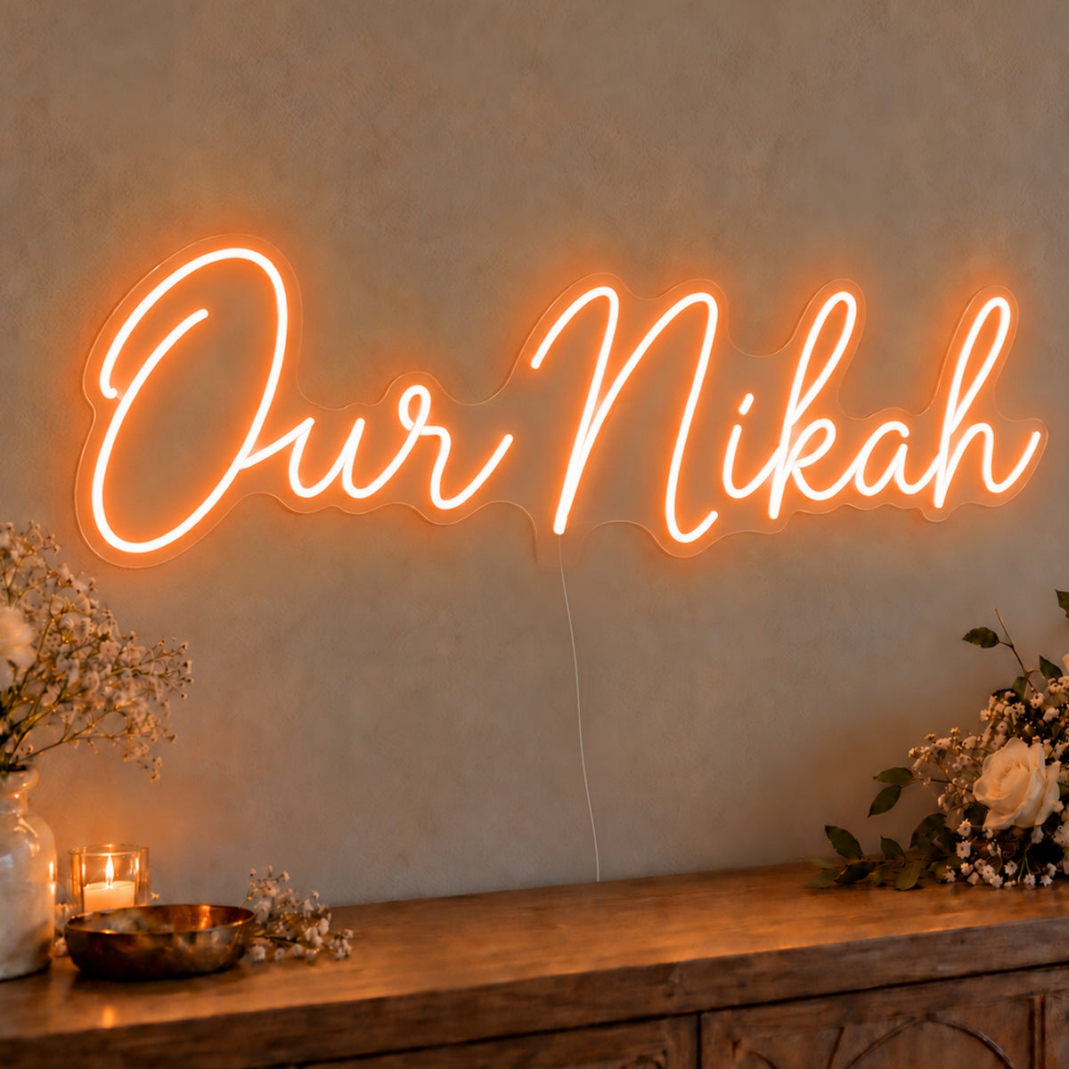 Our Nikah Neon Sign in orange LED neon on clear acrylic, angled view