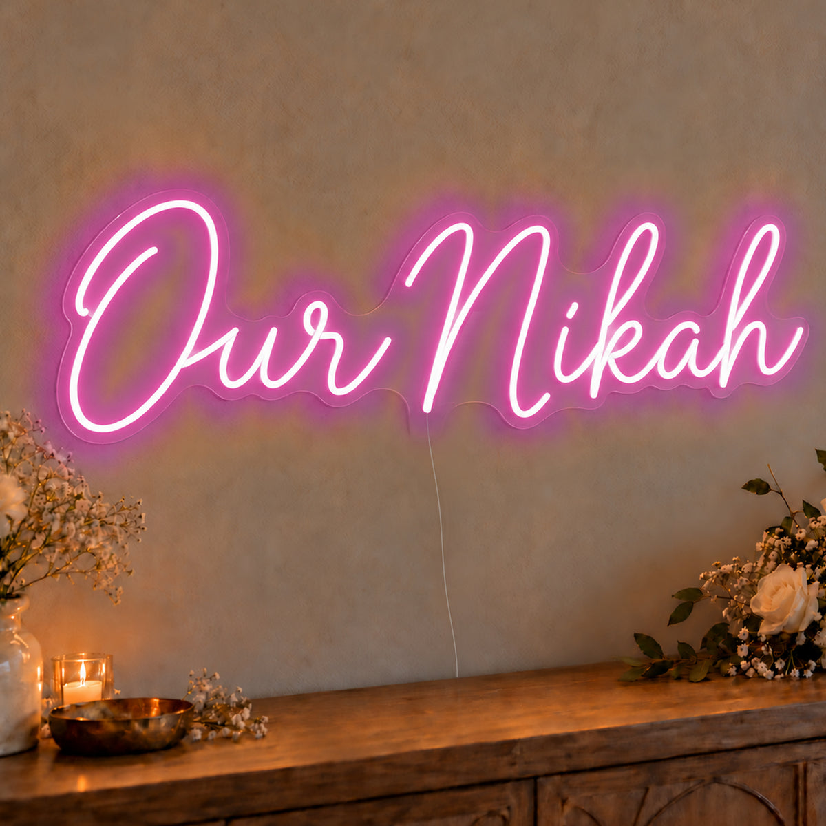 Our Nikah Neon Sign in pink LED neon on clear acrylic, angled view