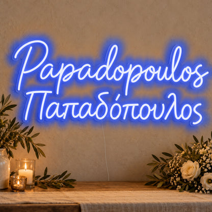 Personalised Bilingual Greek Surname Neon Sign in blue LED neon on clear acrylic, angled view