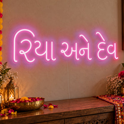 Personalised Gujarati Couple Names Neon Sign in pink LED neon on clear acrylic, angled view