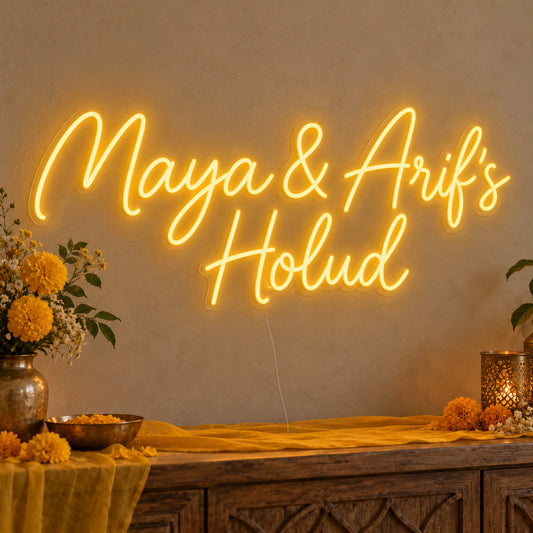 Personalised Holud Neon Sign on clear cut-to-shape acrylic, illuminated on a wall in a styled celebration setting; sample personalised wording shown
