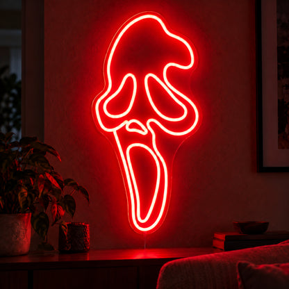 Red Ghostface Neon Sign featuring the Ghostface mask outlined in red, with elongated eyes and an open mouth, displayed on a dark wall above a wooden sideboard.