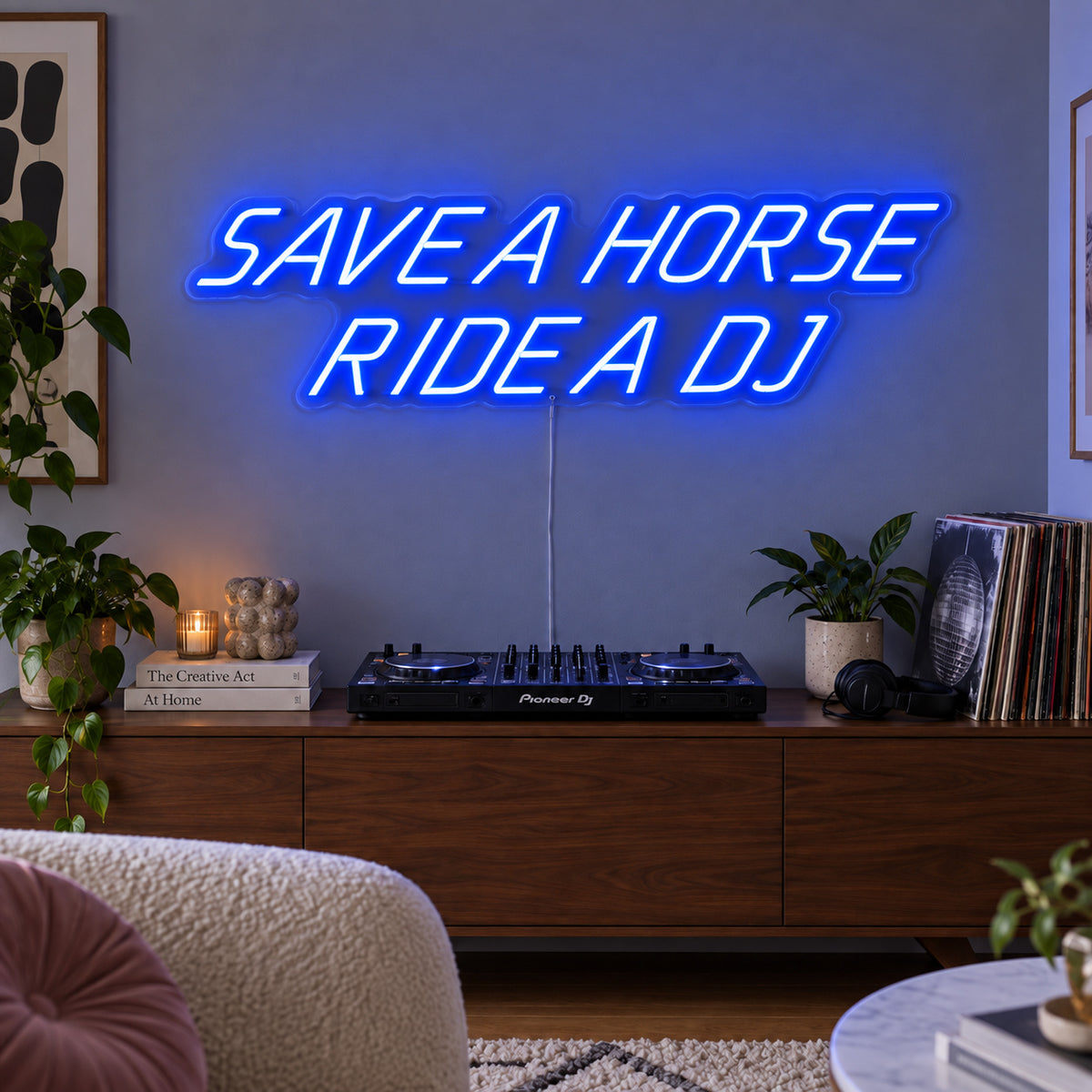Save A Horse Ride A DJ Neon Sign glowing blue above a turntable on a wooden sideboard.