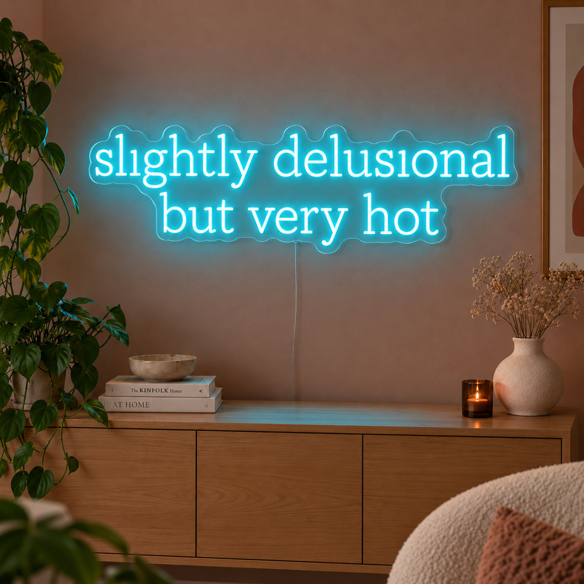 Ice Blue version of the Slightly Delusional But Very Hot Neon Sign, shown above a wooden sideboard.