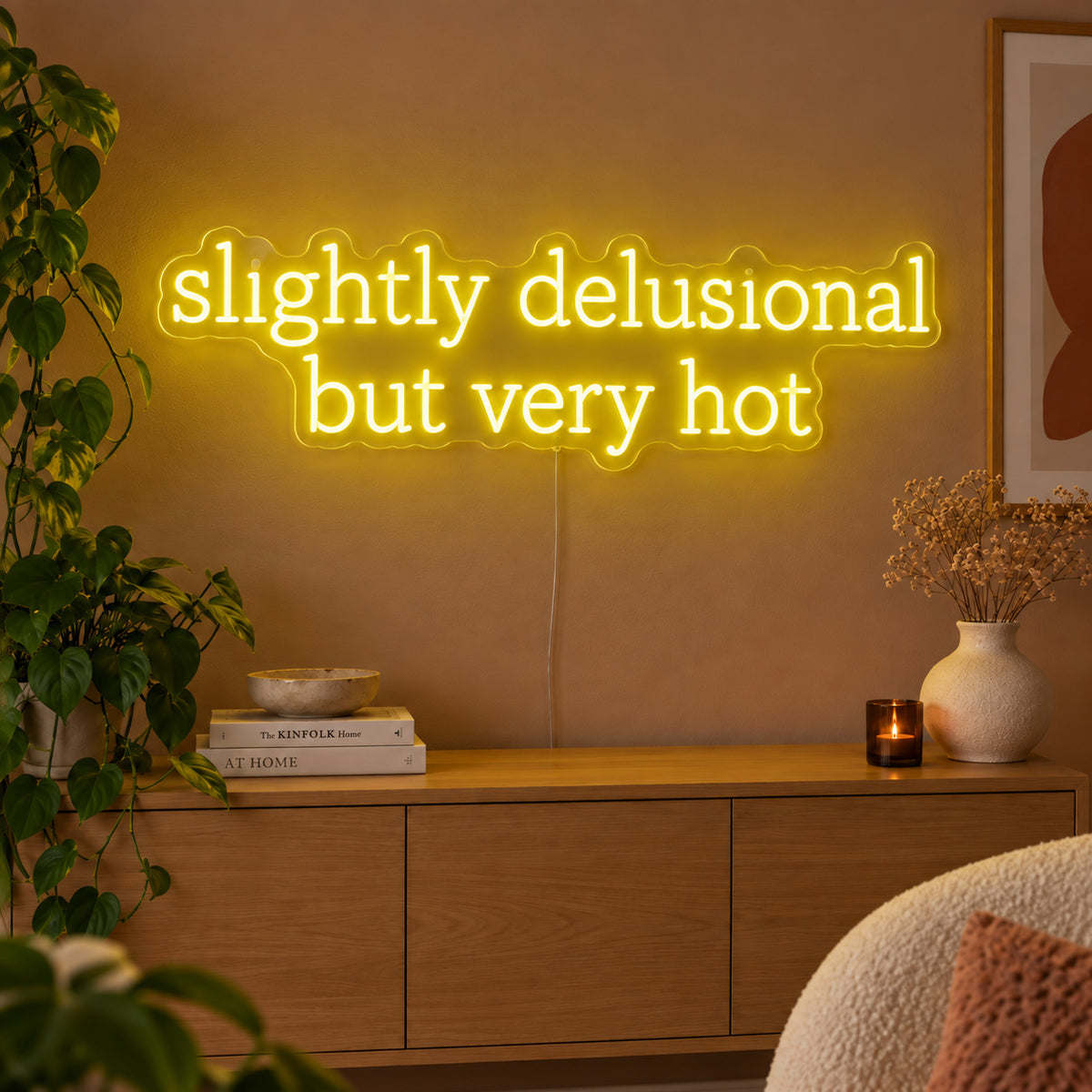 Slightly Delusional But Very Hot Neon Sign with yellow lighting, displayed above a wooden sideboard.