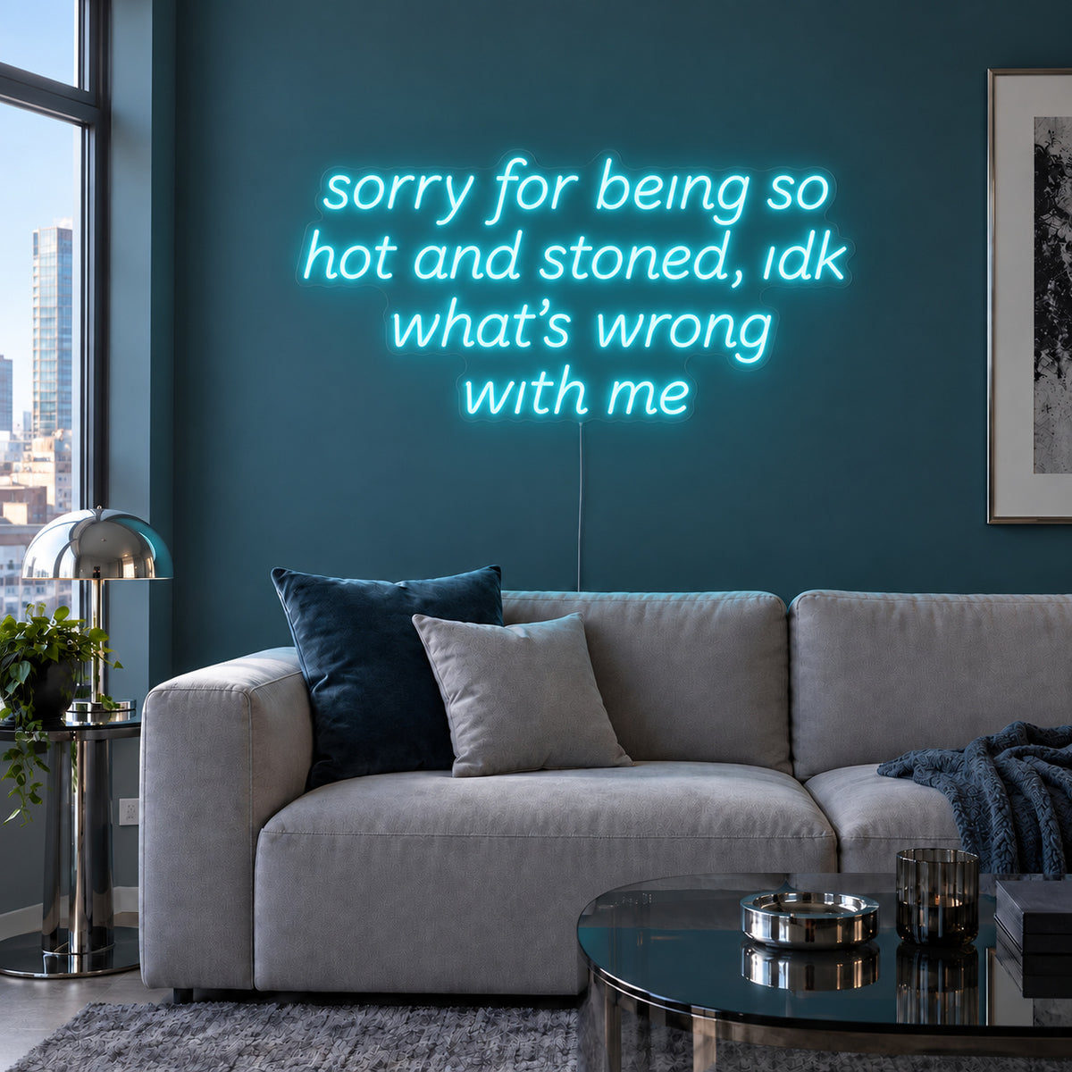 Ice Blue version of the Sorry For Being So Hot And Stoned, Idk What's Wrong With Me Neon Sign, shown above a grey sofa against a blue wall.