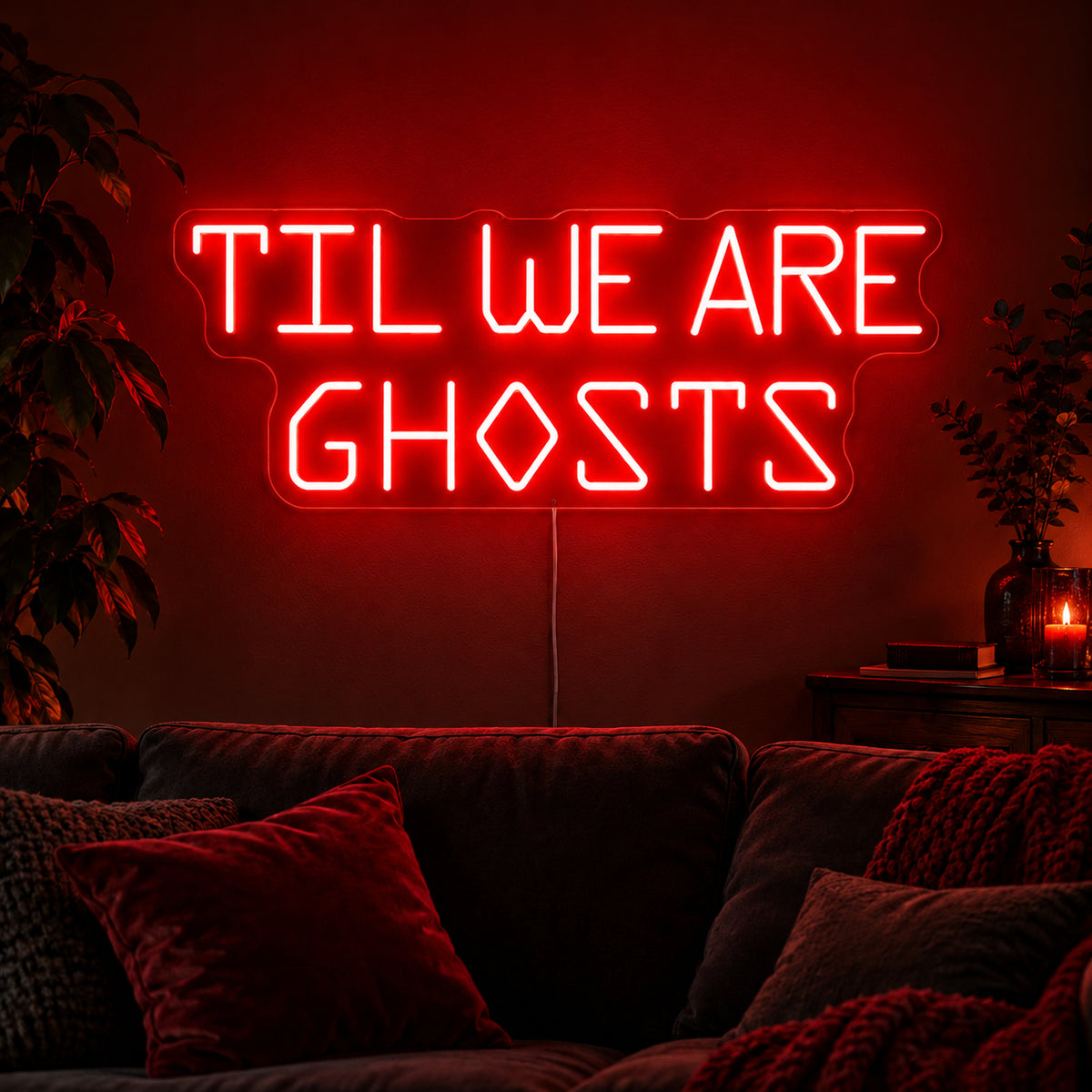 Til We Are Ghosts Block Letter Neon Sign featuring Til We Are Ghosts wording in red geometric block letters, glowing on a dark living room wall.