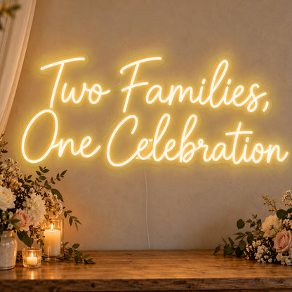 Two Families One Celebration Neon Sign in gold LED neon on clear acrylic, angled view