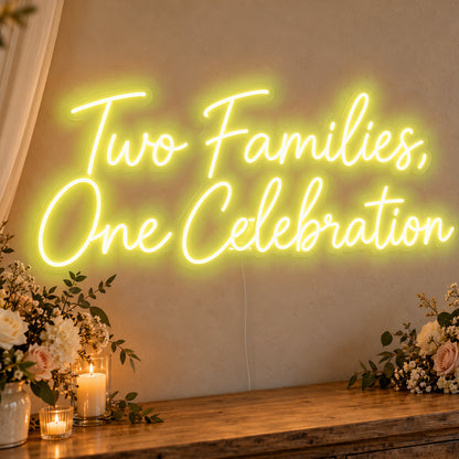 Two Families One Celebration Neon Sign in yellow LED neon on clear acrylic, angled view