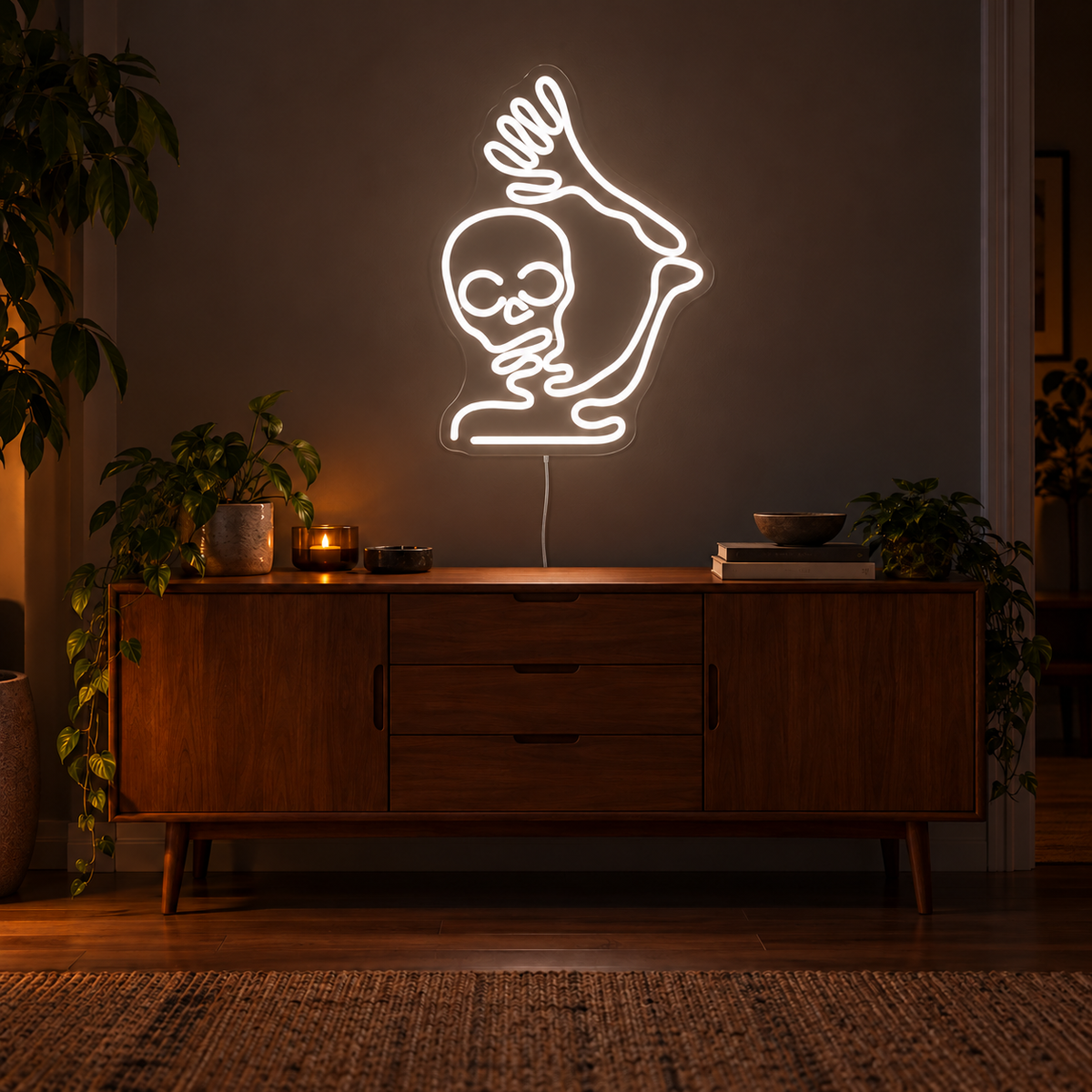 Waving Skeleton Neon Sign featuring a white skeleton with a raised arm and open hand, displayed on a dark wall above a wooden sideboard.