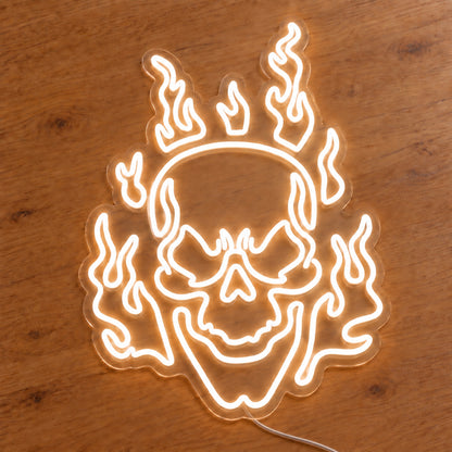 White Flaming Skull Neon Sign featuring a white skull surrounded by curling white flames, illuminated on clear acrylic lying on a natural oak wooden surface.